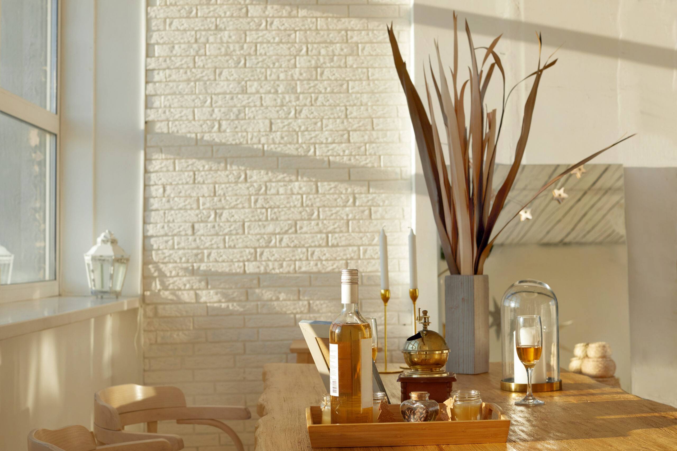 Table with wine and snacks located near chairs in cozy elegant dining room at home