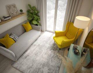 Above angle of a small living room with grey and yellow decor.