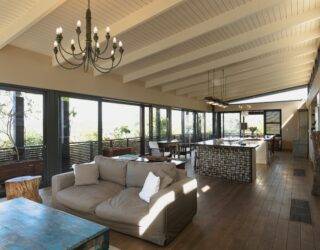 Large open concept room, kitchen behind the living room couch.