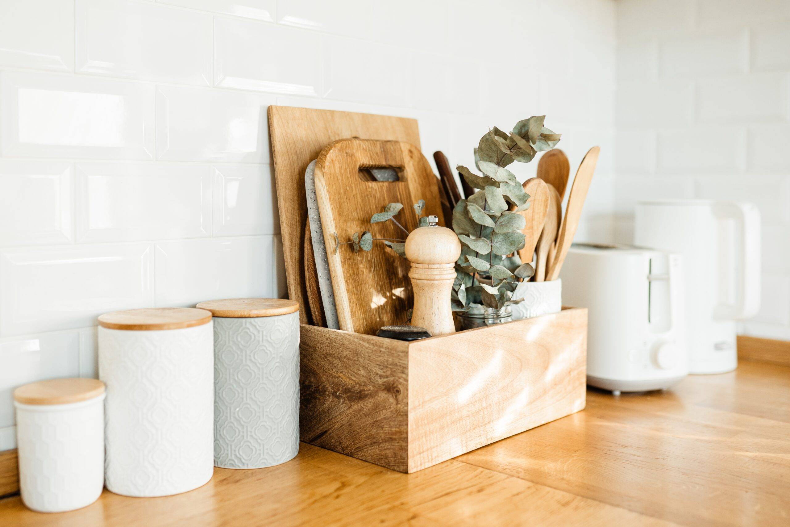 kitchen details, accessories, ceramic jars, wooden table, white ceramic brick wall background. Sustainable living eco friendly kitchen.