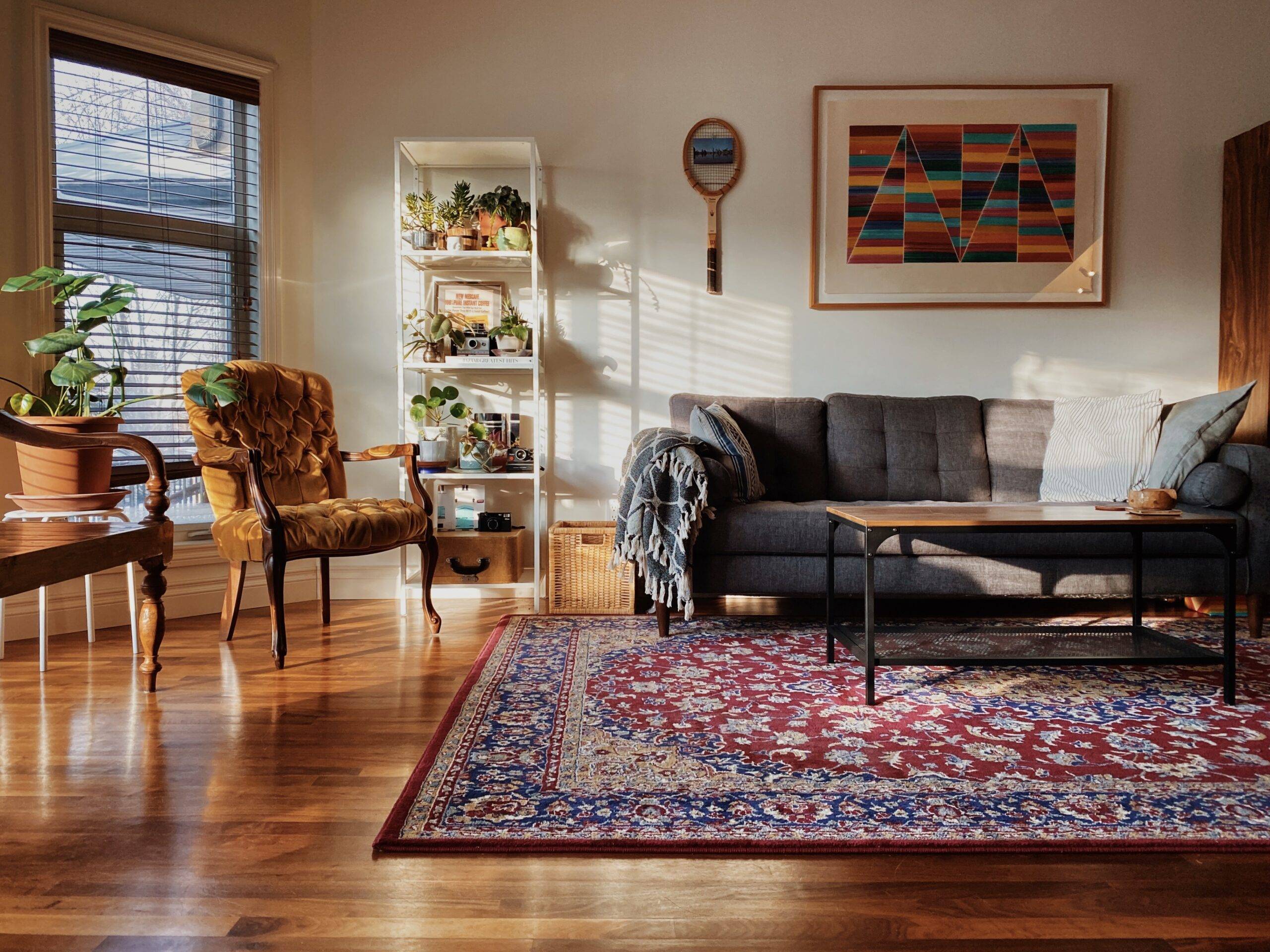 A living room with a large rug in the center.