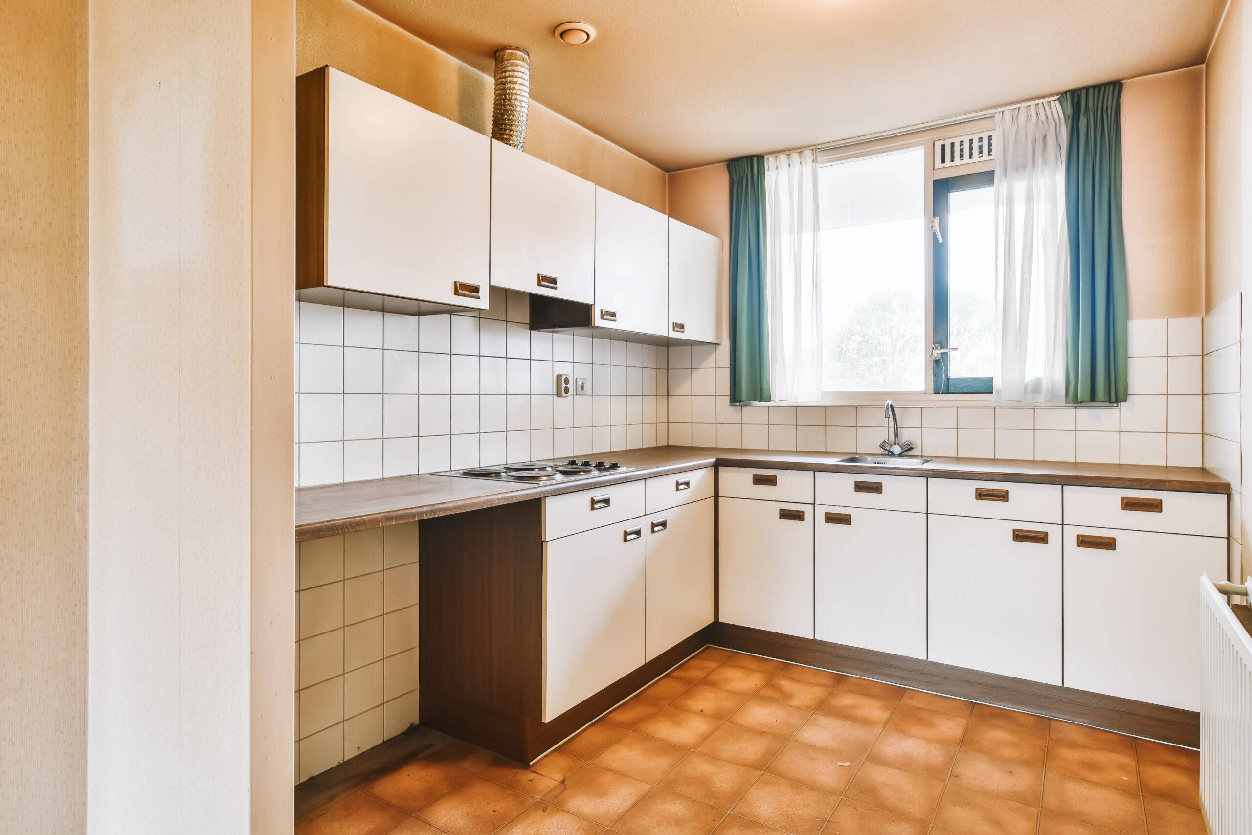 Lovely kitchen with brown tiled floor and window