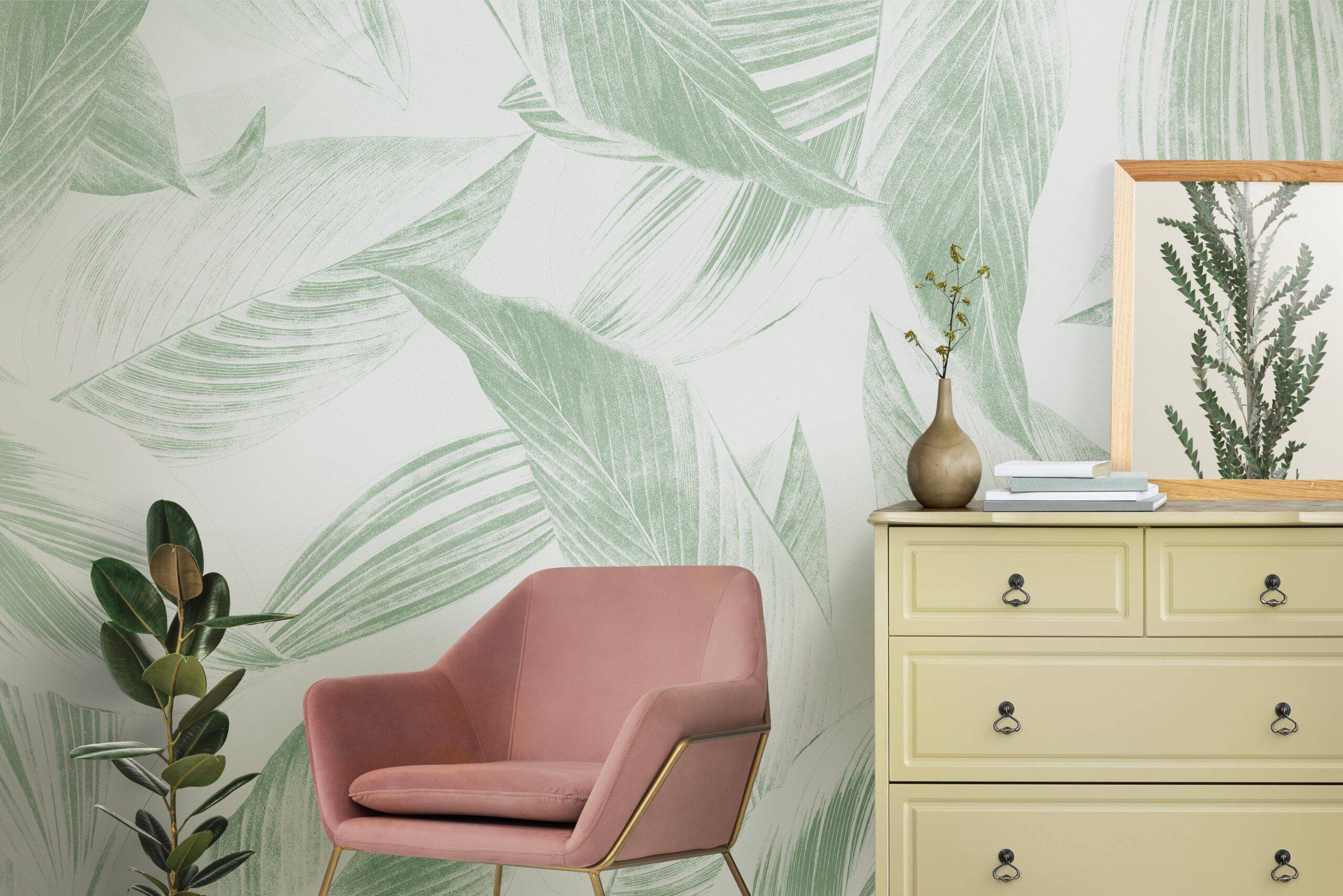 A section of a living room, zooming in on a chair and dresser with accessories, a large print leafy wallpaper behind.