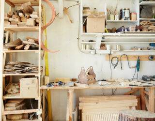 Workbench of carpenter with assortment of wooden workpieces, toolbox and other equipment