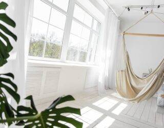 A large window shining natural light into a white room.
