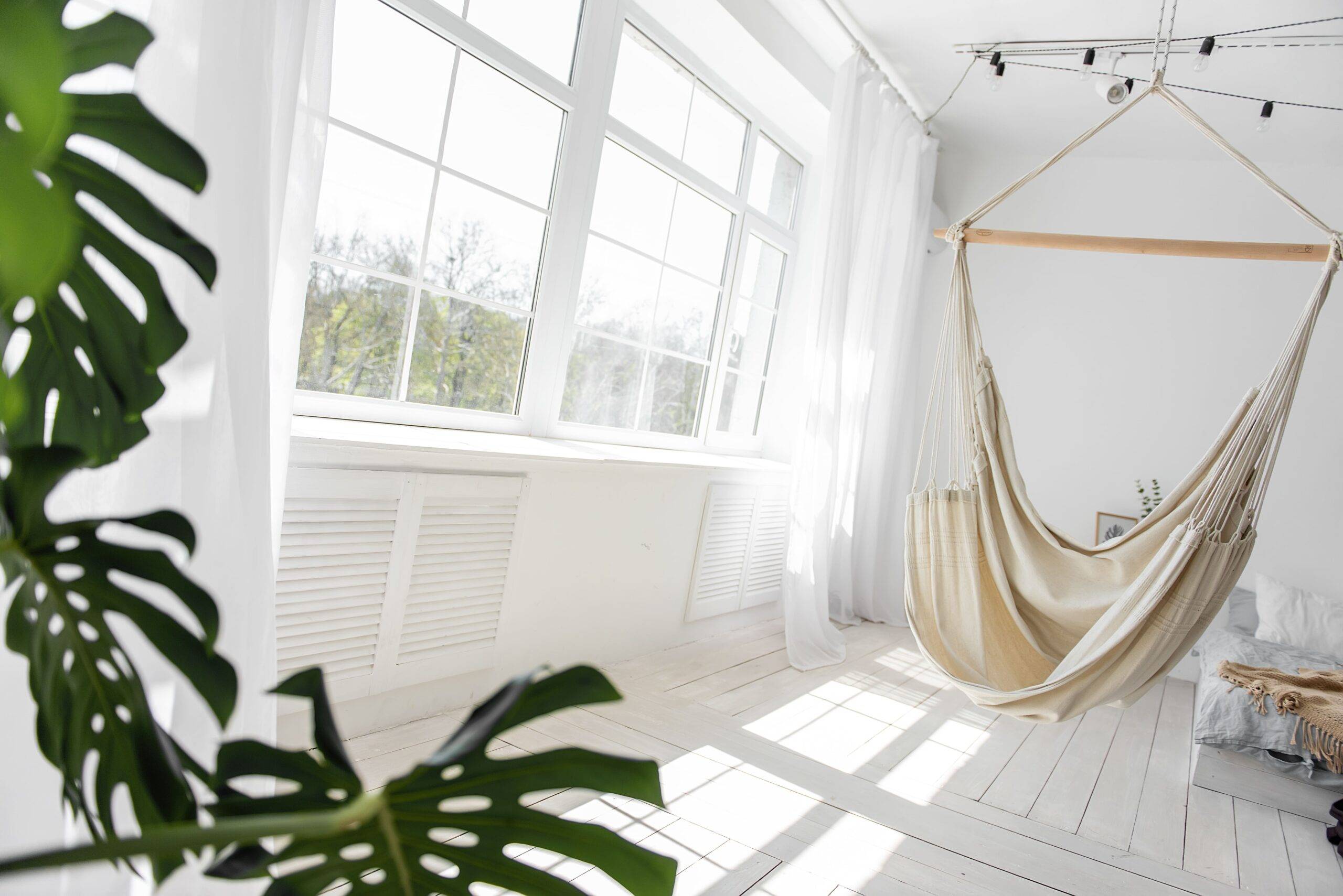 A large window shining natural light into a white room.