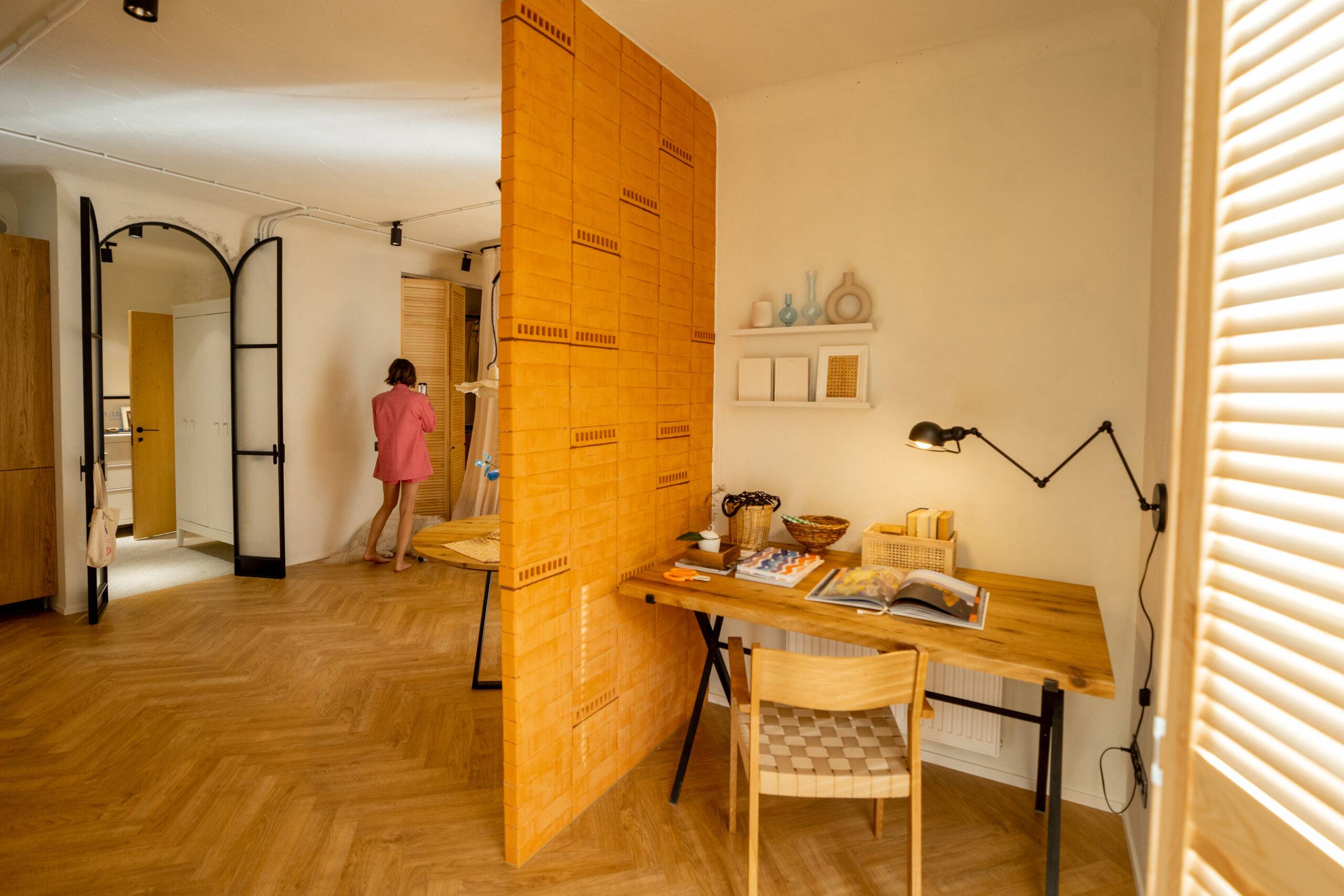 Interior view of workspace separated by a brick wall in stylish studio apartement