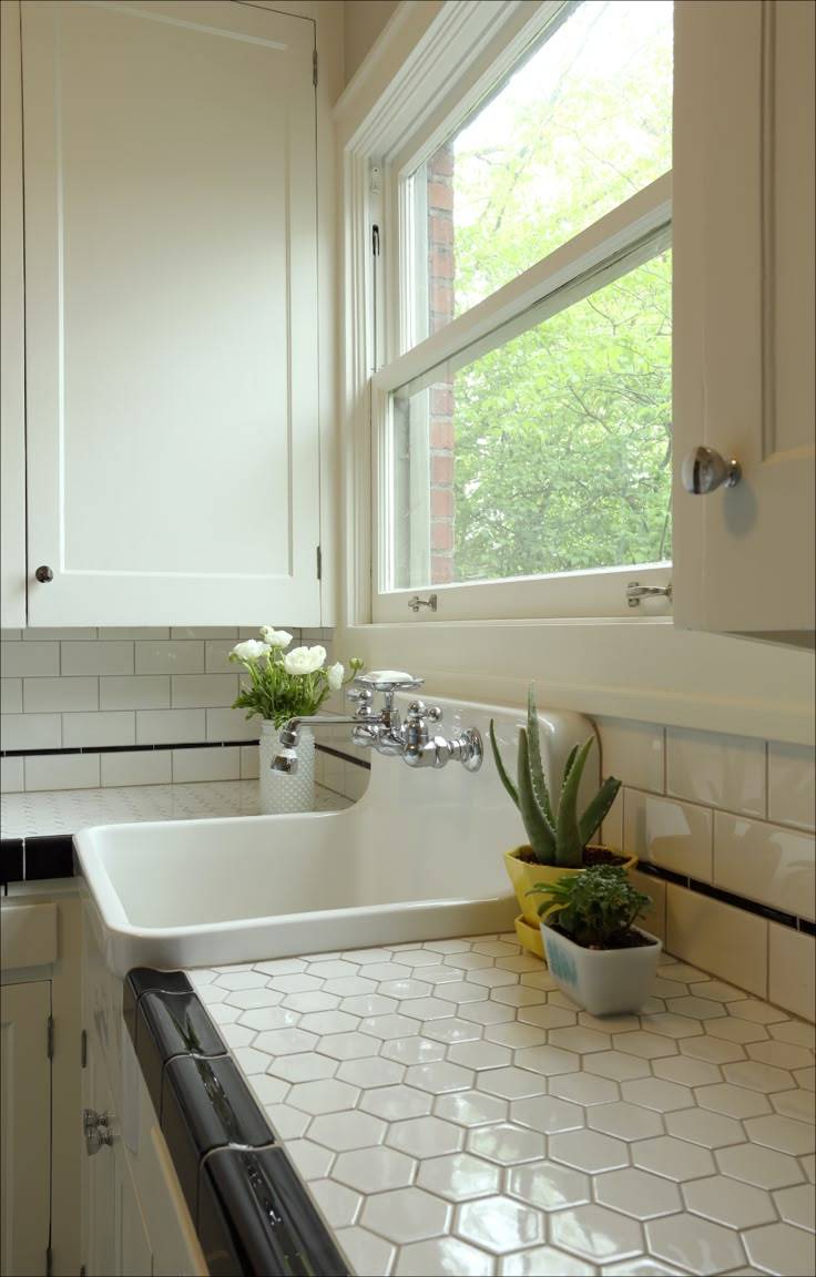 A kitchen with white and black tiled countertops.