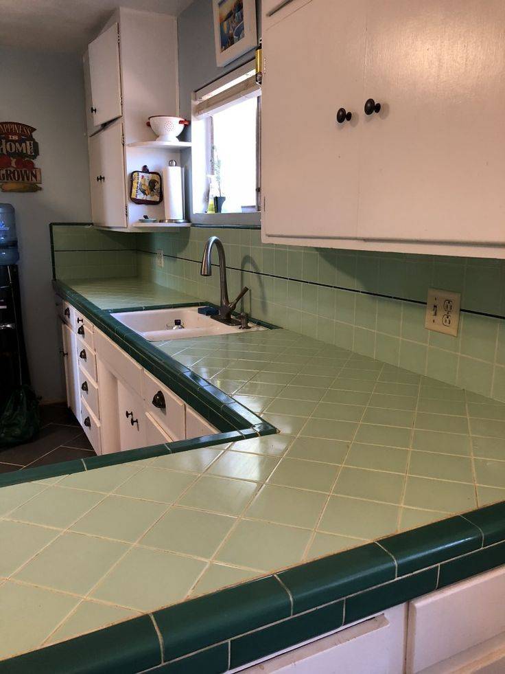 A kitchen with green tiled counters.