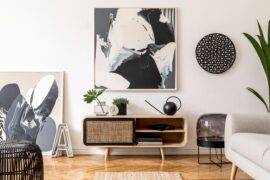 A large black and white piece of abstract art above a small console table.