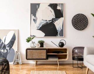 A large black and white piece of abstract art above a small console table.