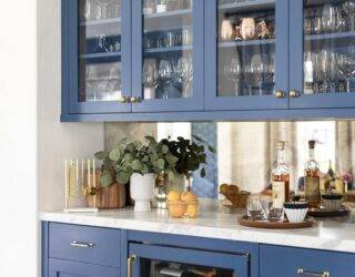 Blue glass-front cabinets holding largely glassware with a white countertop.