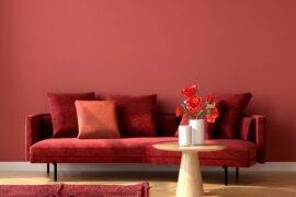 A monochromatic room with red walls, a red couch, and a red rug.