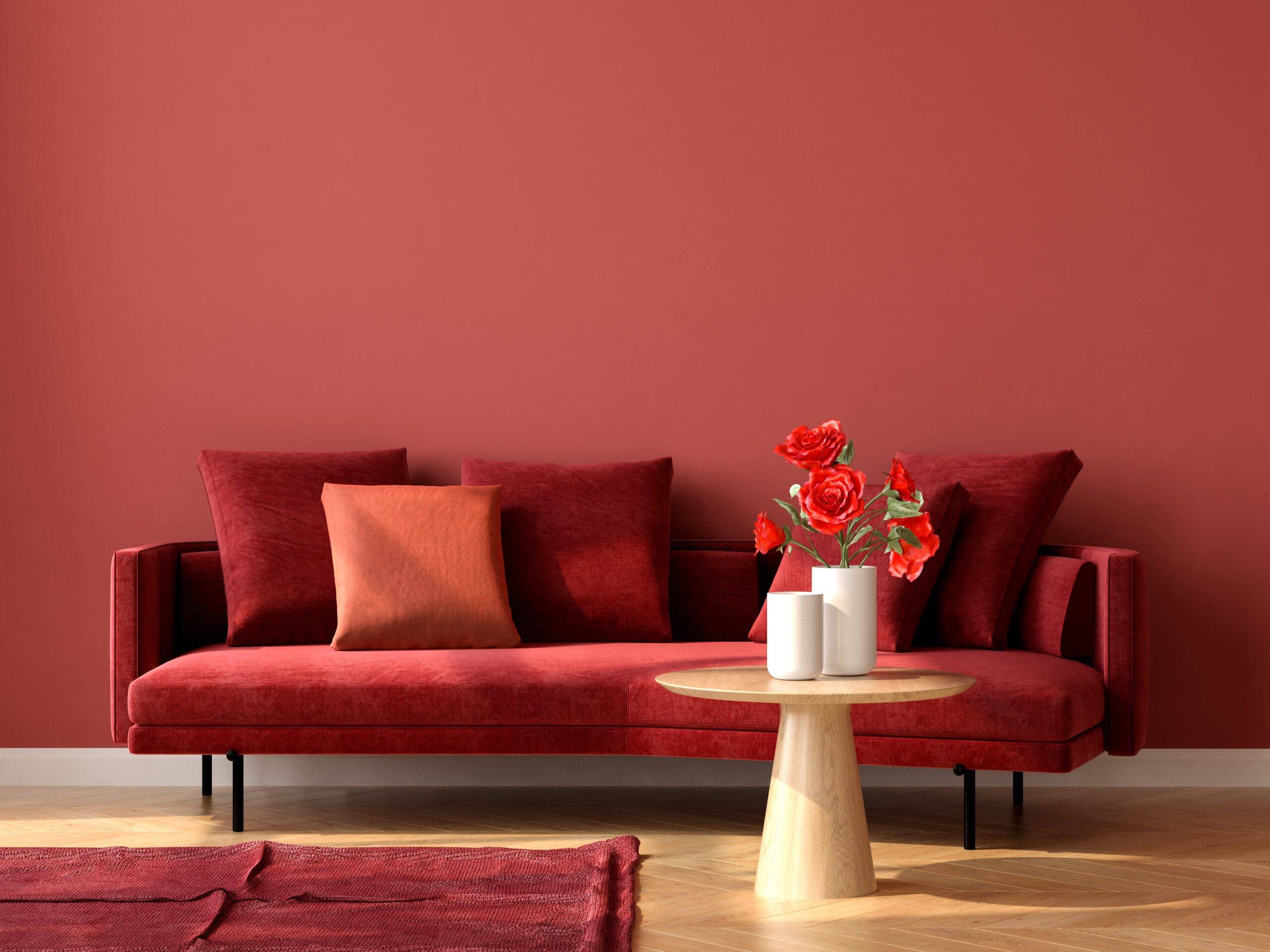 A monochromatic room with red walls, a red couch, and a red rug.