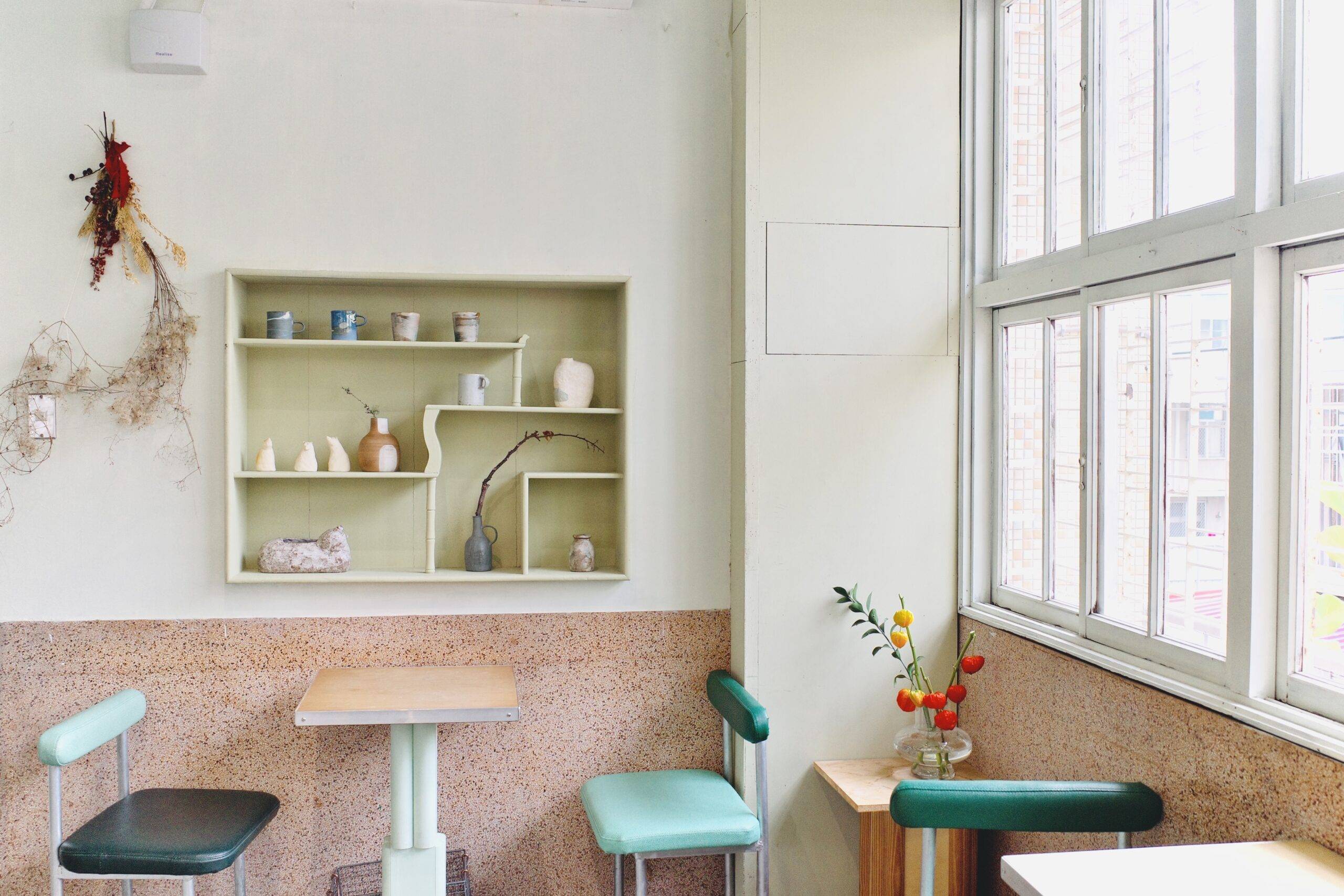 A pastel, retro interior with built in shelves filled with small vintage trinkets.