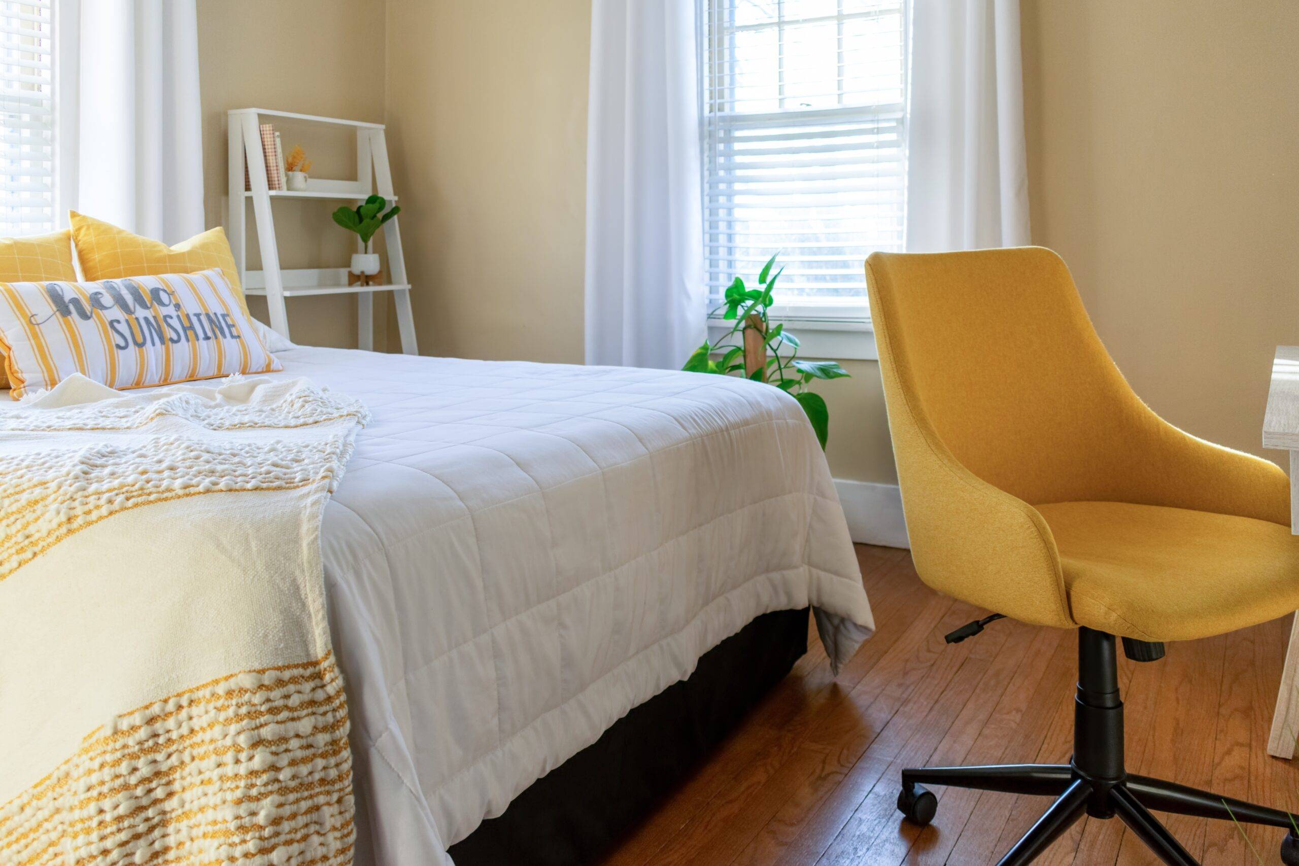 Small stylish bedroom with desk decorated in yellow and white