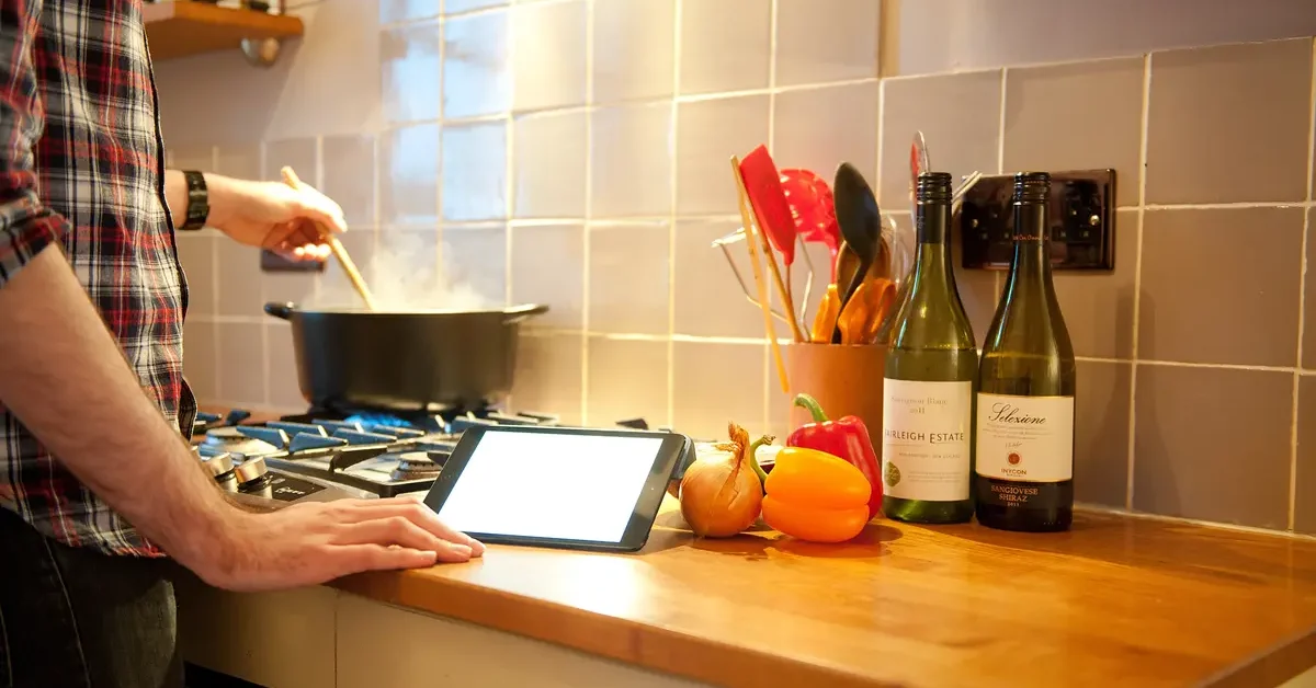A man using an Apple iPad Mini tablet computer in a kitchen setting, January 17, 2013.