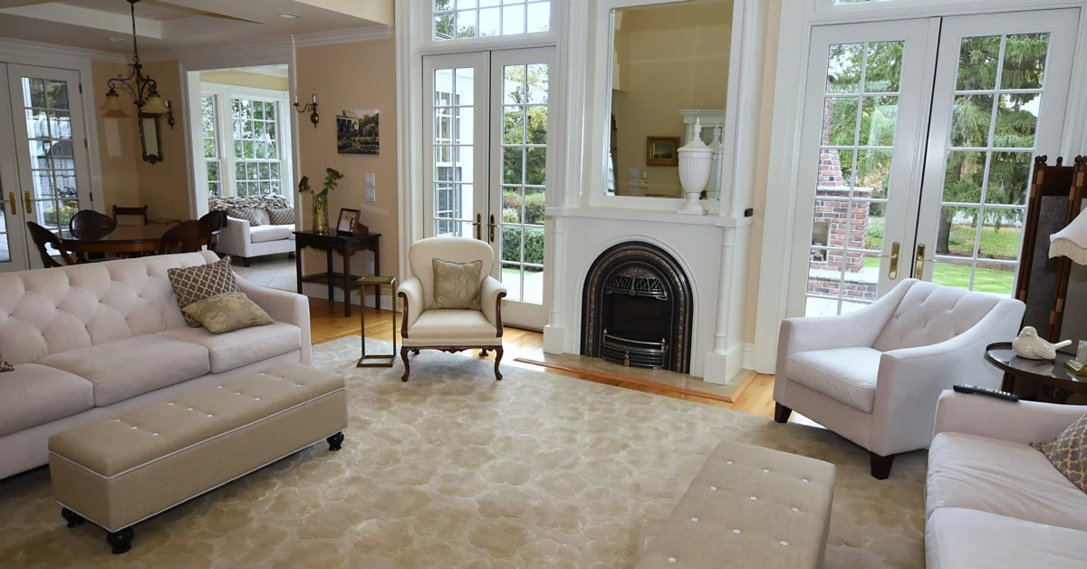 Well-lit, spacious living room, with heavy but sparse furniture.